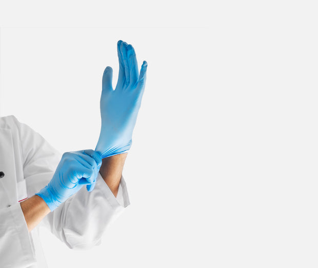 Person legt blaue Nitrilhandschuhe an, Nahaufnahme der Hände