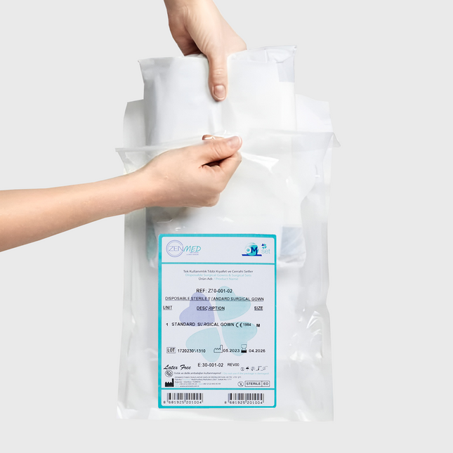 Steriler Einweg-OP-Kittel im transparenten Set von ZENMED/OM Set – in Verpackung, von zwei Händen gehalten

